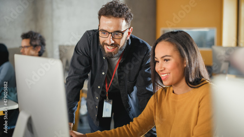 Lecturer Helps Scholar with Project, Advising on Their Work. Teacher Giving Lesson to Diverse Multiethnic Group of Female and Male Students in College Room, Teaching New Academic Skills on a Computer.