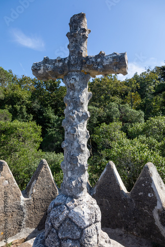 An ancient stone cross in a relict forest on the way to Cruz Alta in Bussaco Park. Coimbra. Portugal