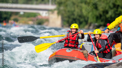 Two girls enjoying themself with river rafting water sports. Smiles, recreation and happiness concept. Removed logos.