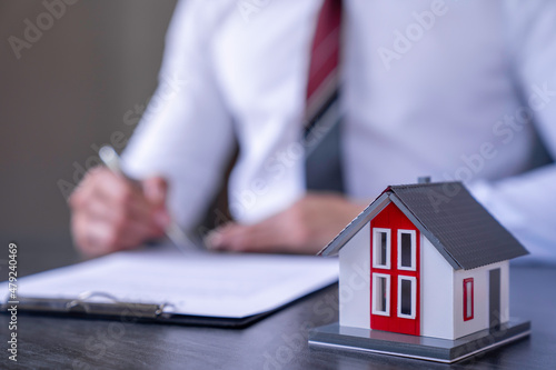 Businessman is signing a contract to make insurance and buy a successful house project , home insurance ideas home and land mortgage