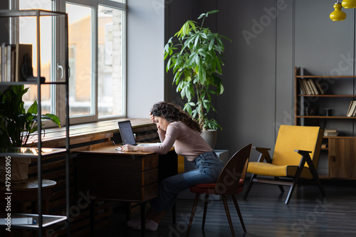 Work fatigue. Young woman freelancer feeling tired, exhausted and unproductive while sitting at her workplace at home, photo of overworked remote female employee. Emotional burnout of employees