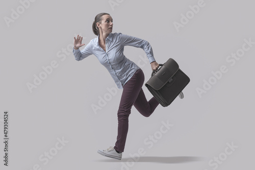 Scared businesswoman running away from a danger