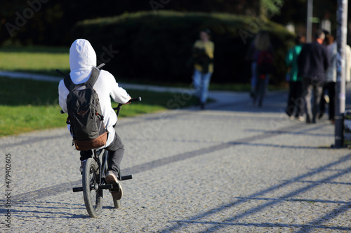 Mężczyzna na rowerze z plecakiem jedzie ścieżką rowerową w mieście, Wrocław. 