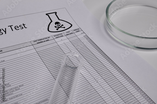 Toxic test log with petri dish and glass tube. Paper logs for toxicology exams. Mortal records in chemical laboratory. Deadly investigation concept. List of safety parameters in science, medical