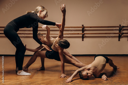 group of little girls at a group training session in a dance studio watch as they learn a new dance with a choreographer