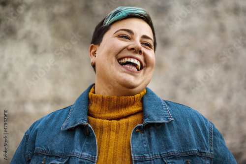 Smiling non-binary young woman with a confident and positive attitude, embracing her unique identity and style