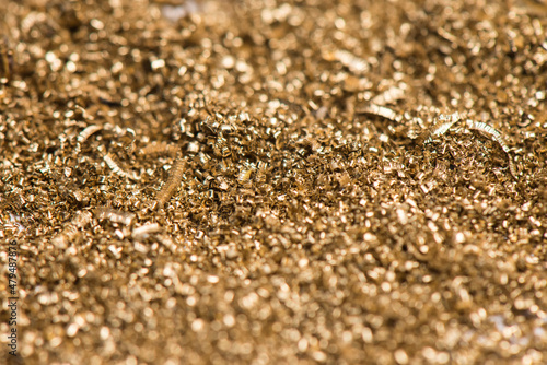 Small shavings of brass after lathe work. Industrial waste from the metallurgical industry. Selective focus.