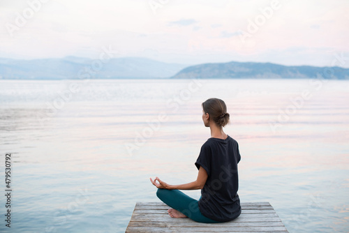 Beautiful woman practicing yoga near the sea, Young girl meditate at sunset, Harmony, meditation, healthy lifestyle and travel concept