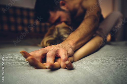 Close up image of intimate couple holding hands while having sex on bed - Boyfriend and girlfriend enjoying sensual foreplay on bedroom - Love concept