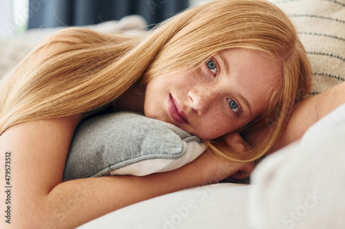 Conception of beauty. Female teenager with blonde hair is at home at daytime