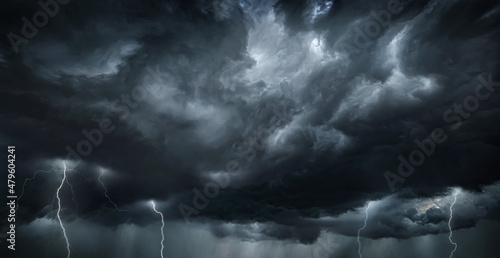 Thunderous dark sky with black clouds and flashing lightning. Panoramic view. Concept on the theme of weather, natural disasters, storms, typhoons, tornadoes, thunderstorms, lightning, lightning.