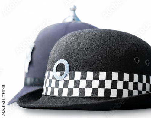 Law enforcement careers concept. Headwear similar in style to UK police- female Chief constable patrol hat in front of Male mobilefoot patrol Sergeant/Constable custodian helmet as worn at incidents.