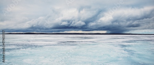 Frozen forest lake on a cloudy day. Dramatic sky after a blizzard. Onega, Karelia, Russia.Atmospheric winter landscape. Panoramic view. Nature, climate change, christmas vacations, eco tourism