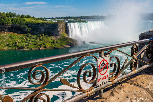 A danger do not climb sign on the railing at the edge of the gorge in Niagara Falls Ontario Canada.