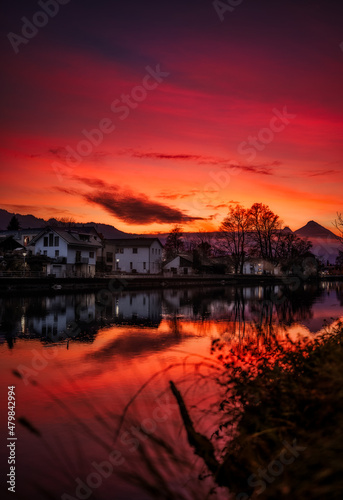 Fire Sunset over Interlaken A beautiful, fiery sunset over one of the rivers in Interlaken, with some residential houses along the river. 