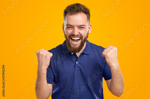 Positive man celebrating victory with clenched fists
