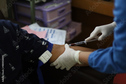 Close up Hand of nurse, doctor or Medical technologist in blue gloves taking blood sample from a patient in the hospital.