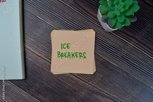 Ice Breakers write on sticky notes isolated on Wooden Table.