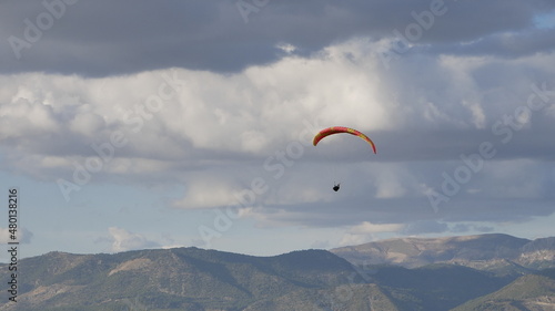 Paragliders flying in a dramatic sky of storm clouds over Cenes de la Vega, Granada, Spain