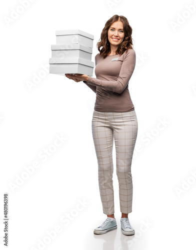 sale, shopping and business concept - happy female shop assistant or saleswoman holding three shoe boxes white background