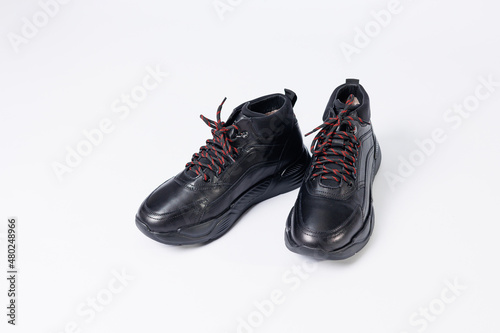 Leather black short men's autumn sneakers on a white background. Sneakers winter collection 2022.