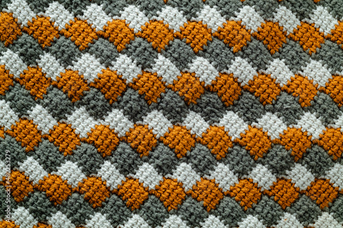 Tunisian crochet fabric. Crocheted white, yellow, grey entrelac.