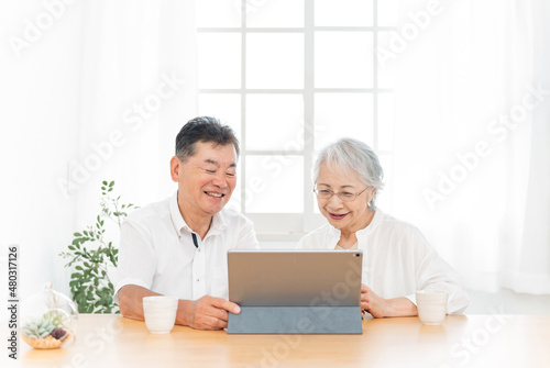 タブレットPCを見る高齢者夫婦（笑顔） 