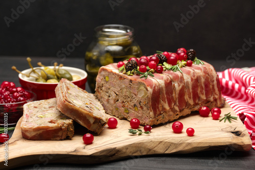 Traditional French terrine covered with bacon on dark wooden background