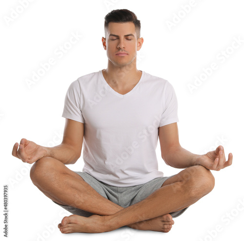 Handsome man meditating on white background. Harmony and zen