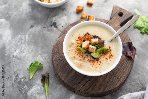 Mushroom cream soup with croutons served on concrete background. Soup in a bowl. Top view 