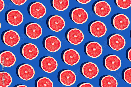 Minimal fruit pattern with grapefruit on blue background. Creative summer mood. Healty concept. Organic fruit. Flat lay. Trendy social mockup or wallpaper.