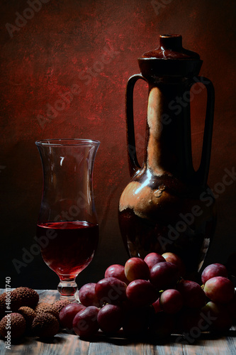 Karafka i kieliszek, czerwone wino. Winogrona różowe i liczi. Kompozycja martwa natura jako tekstura tła lub na tapetę.