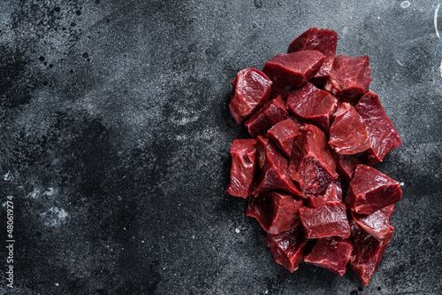 Raw sliced Beef or veal heart. Black background. Top View. Copy space