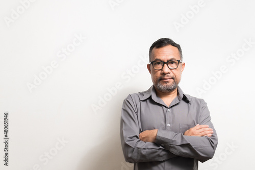 40-50 years old Asian businessman folded his arms and smiled happily after successfully investing in finance, banking, real estate, oil, petroleum. Copy space on left, Blurred, White background