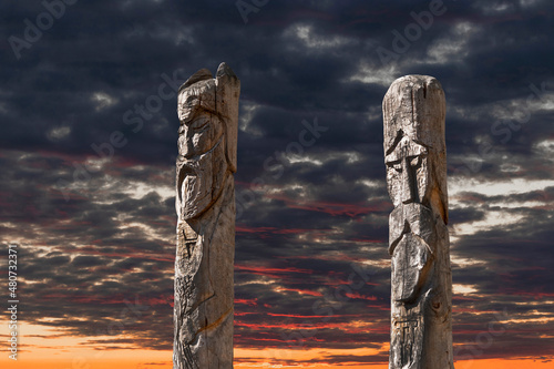 Northern lands. A pagan temple in the taiga with two wooden idols. The image of pagan gods is carved on wooden logs.