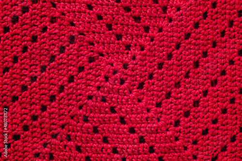 Knitted red texture. Crocheted granny square.