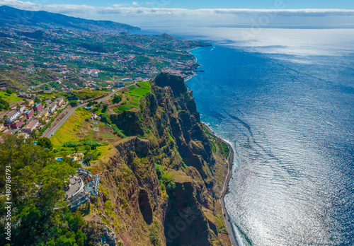 Aerial drone view of Cabo Girao - a lofty sea cliff located along the southern coast of the island of Madeira. The observation view balcony with glass floor with the elevation of 580m