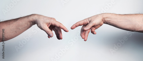Two male hands posing like Da Vinci Creation of Adam masterpiece