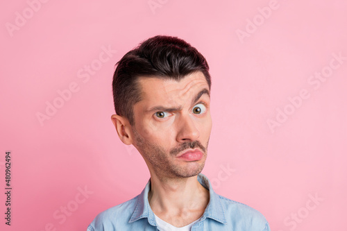 Portrait of uncertain bighead man doubtful suspicious wearing casual clothes isolated pastel pink color background