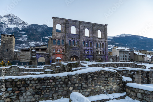 Aosta, roman teatre with snow at sunset. Remains of the Roman theater, built in 25 BC. covered with snow during the Christmas holidays