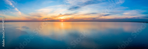 Wide aerial panorama of seascape - sunset reflecting in calm sea