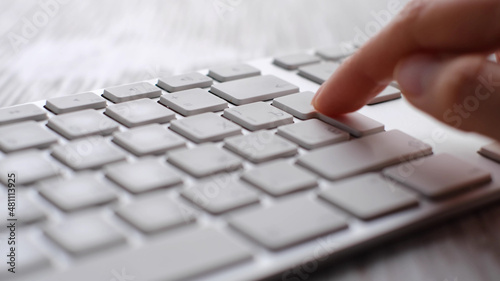 Finger pressing an enter key. Computer user hitting the enter key, up close. Confirmation, sending a message