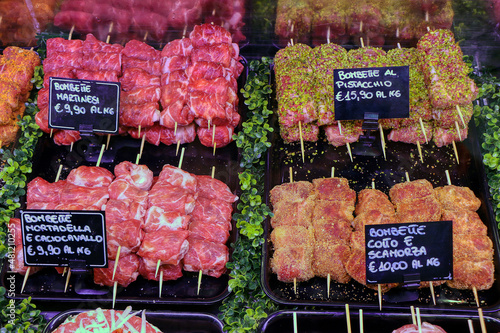 Various types of the famous bombette martinesi for sale in a butcher's shop. Meat rolls stuffed with cheese. In the signs written in Italian the various types of tastes
