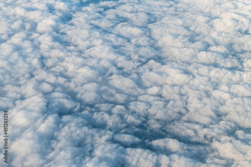 Flying above United Kingdom Scotland with cloudscape aerial high angle view above of abstract dark cloudy landscape sky pattern of white clouds from airplane