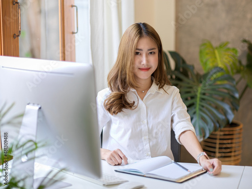 Elegant and beautiful businesswoman sitting at her modern office desk