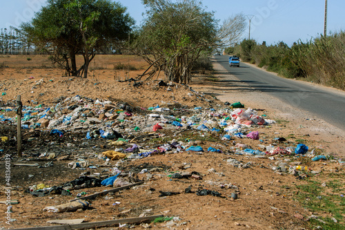 photo of scattered garbage by the road. The concept of waste disposal and environmental pollution