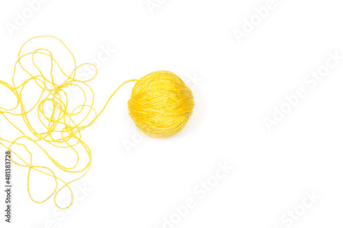 Una bola de lana amarilla sobre un fondo blanco liso y aislado. Vista superior y de cerca. Copy space