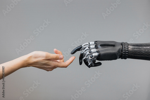 the human hand and the siber hand bionic prosthesis make a handshake and greeting. modern technologies of prosthetics of limbs of hands and feet. full life of people with amputated limbs. black bionic