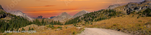 A panorama photo of a gravel county road winding through the San Juan mountains near Ouray Colorado