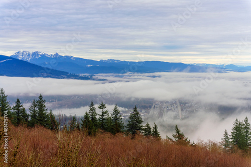 Fraser Valley winter cloud inversion over Port Moody, BC, at Burrard Inlet with alpine mountain backdrop.